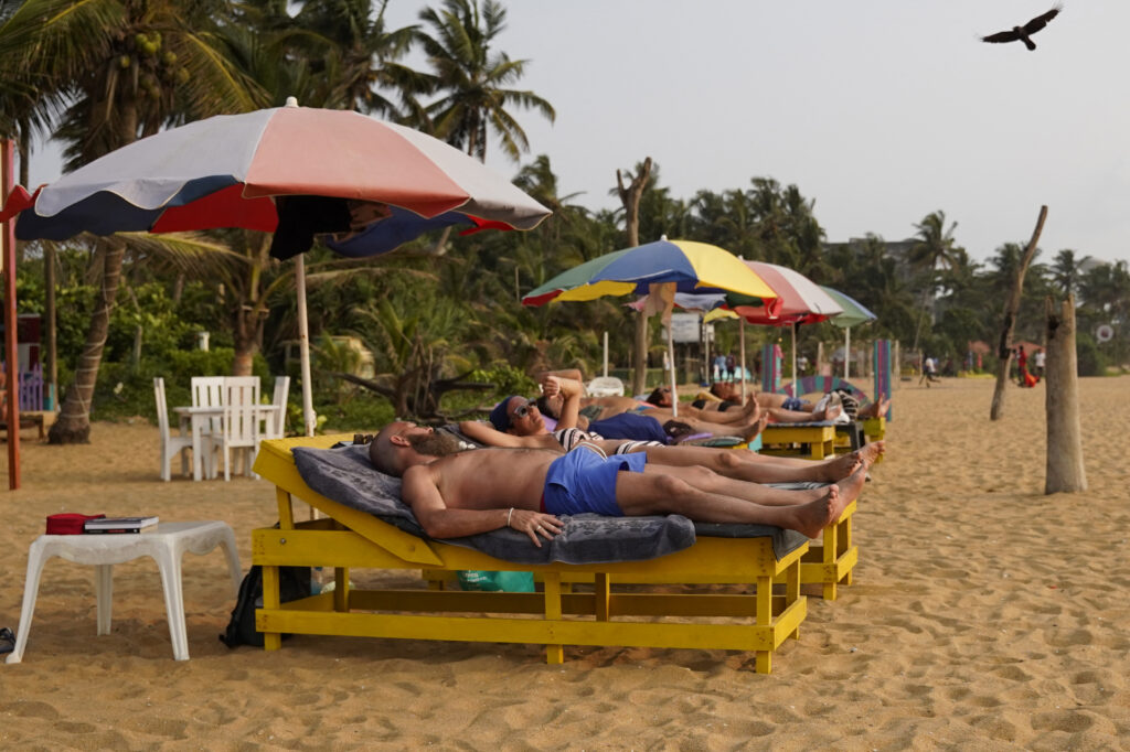 A foreign tourist sunbathes on a Mount Lavinia beach in Colombo, Sri Lanka, on 9 March. US-Israel strikes on Iran spark Gulf retaliation; 10,000 tourists are stranded in Sri Lanka, which grants emergency visa extensions.