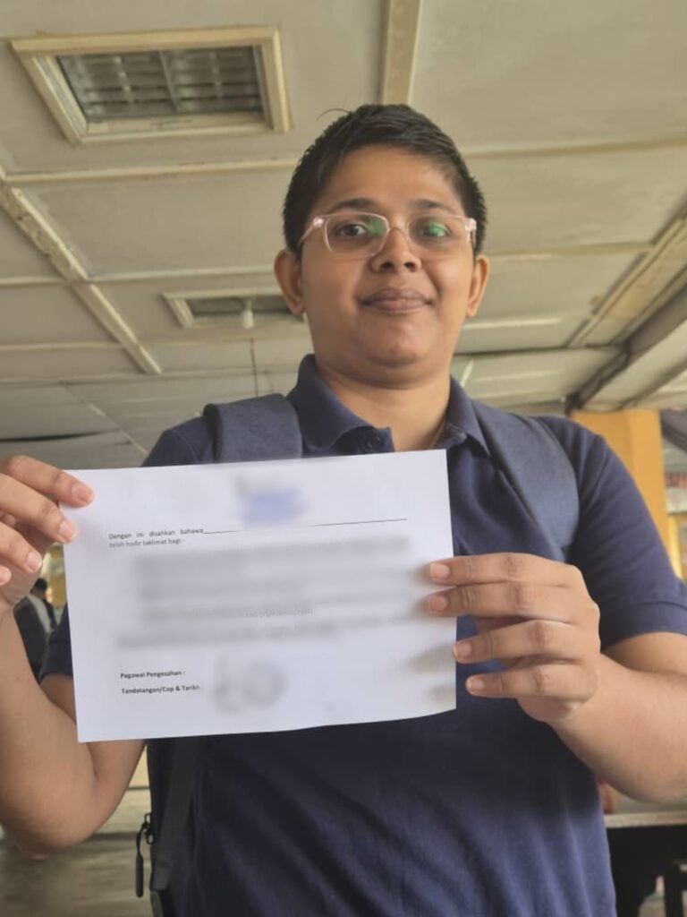 Journalist holds attendance slip from briefing