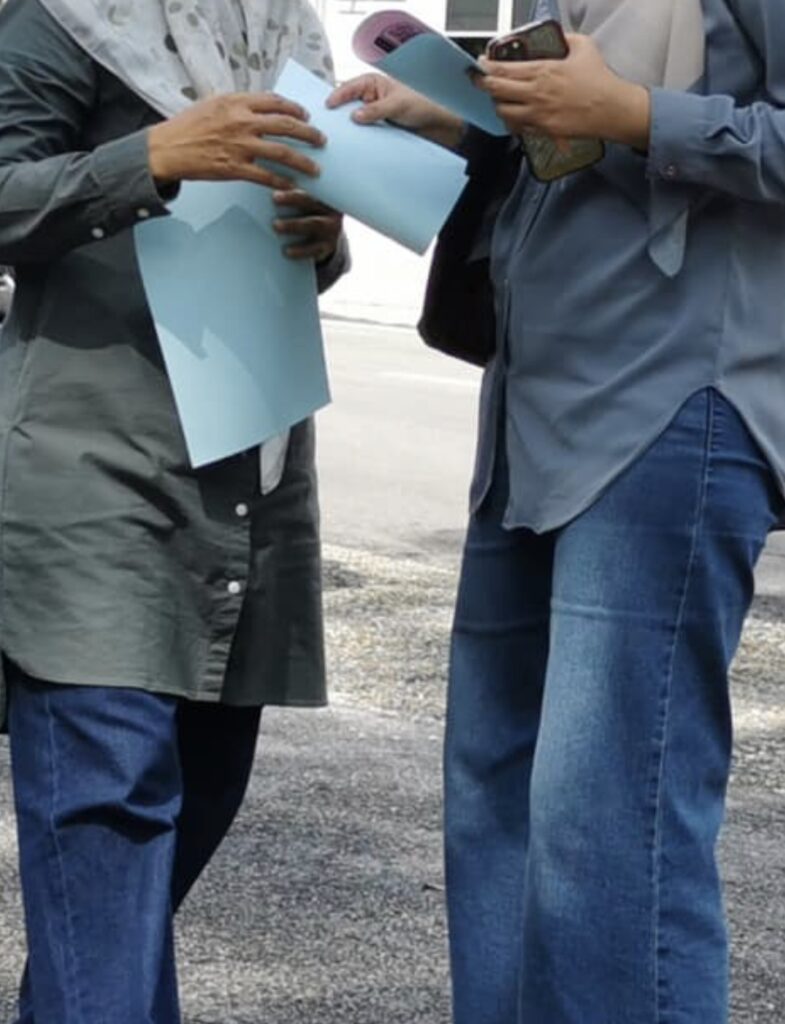 Two people discreetly exchanging documents after a briefing