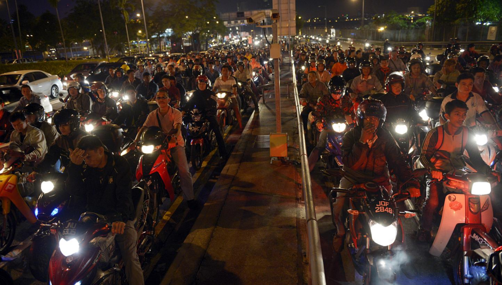 Motorcyclists at the Sultan Iskandar Customs, Immigration and Quarantine checkpoint in Johor Baru waiting to cross over to Singapore.
